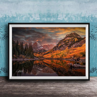 The image is a framed photograph depicting a serene mountain landscape with a lake, trees, and mountains in the background, reflecting the vibrant colors of the sky.