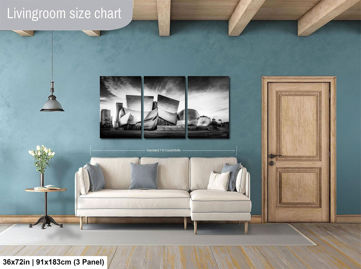 The image is a living room with a large white sofa, a wooden door, and a wall with a large black and white photograph of a city skyline.