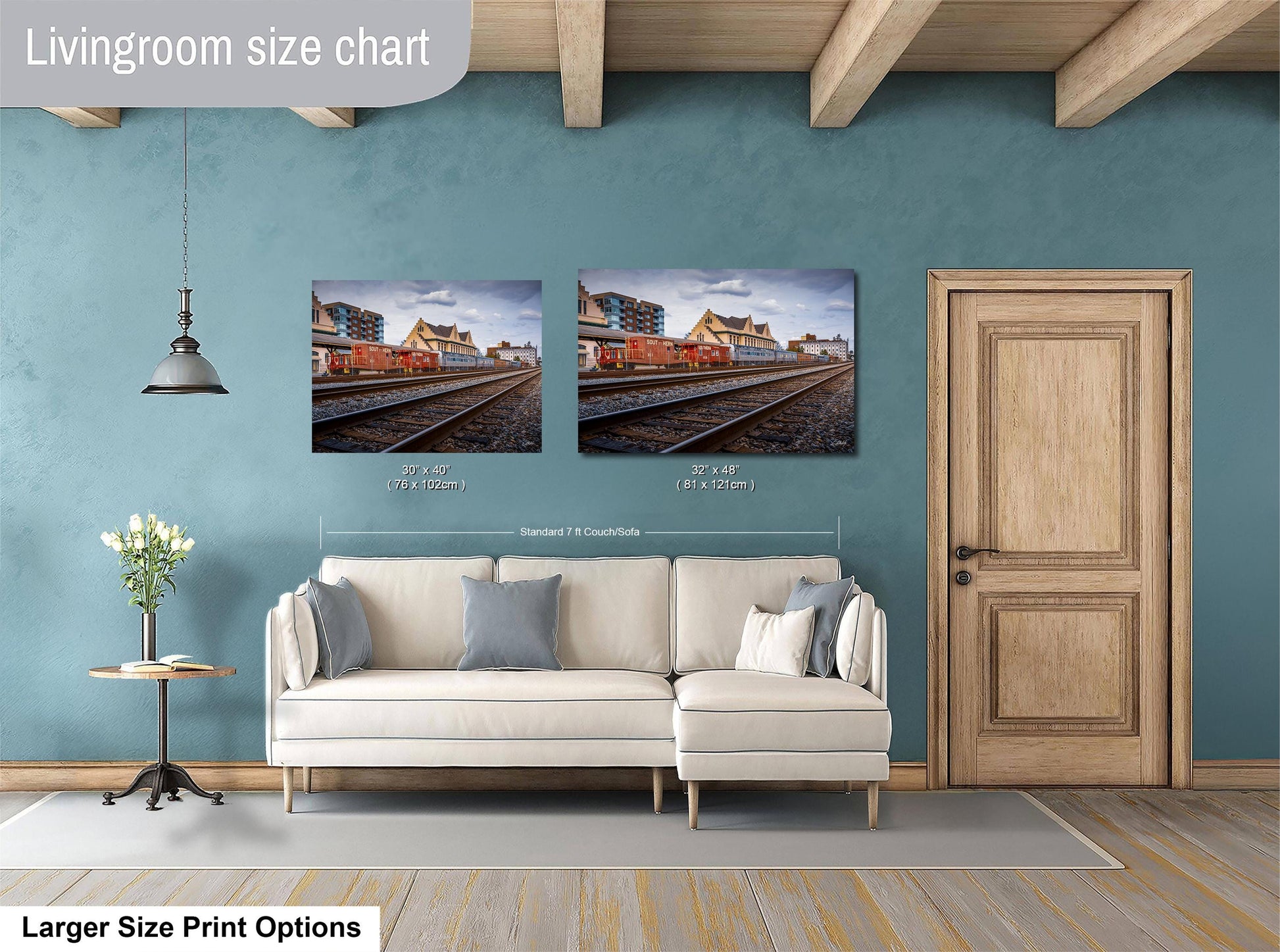 a living room with a white sofa, a wooden door, and two framed pictures of a train on the wall.