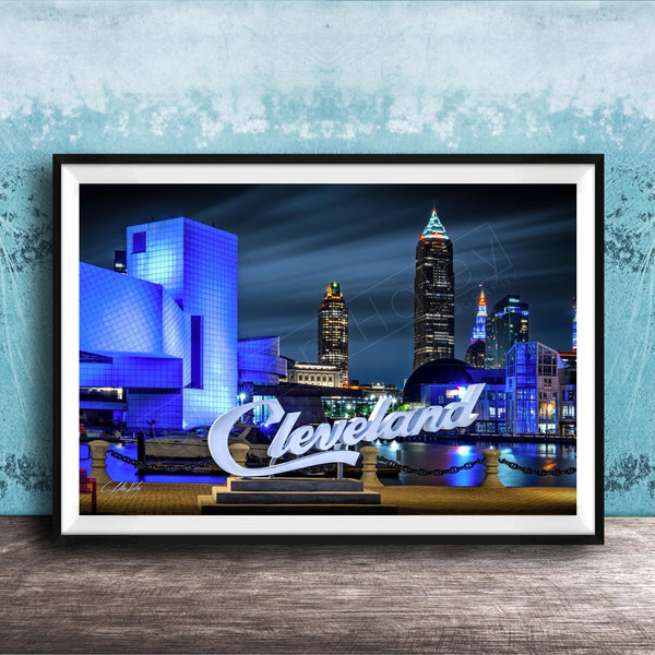 A framed photograph of the Cleveland skyline at night, with the city's iconic landmarks illuminated against a dark sky.