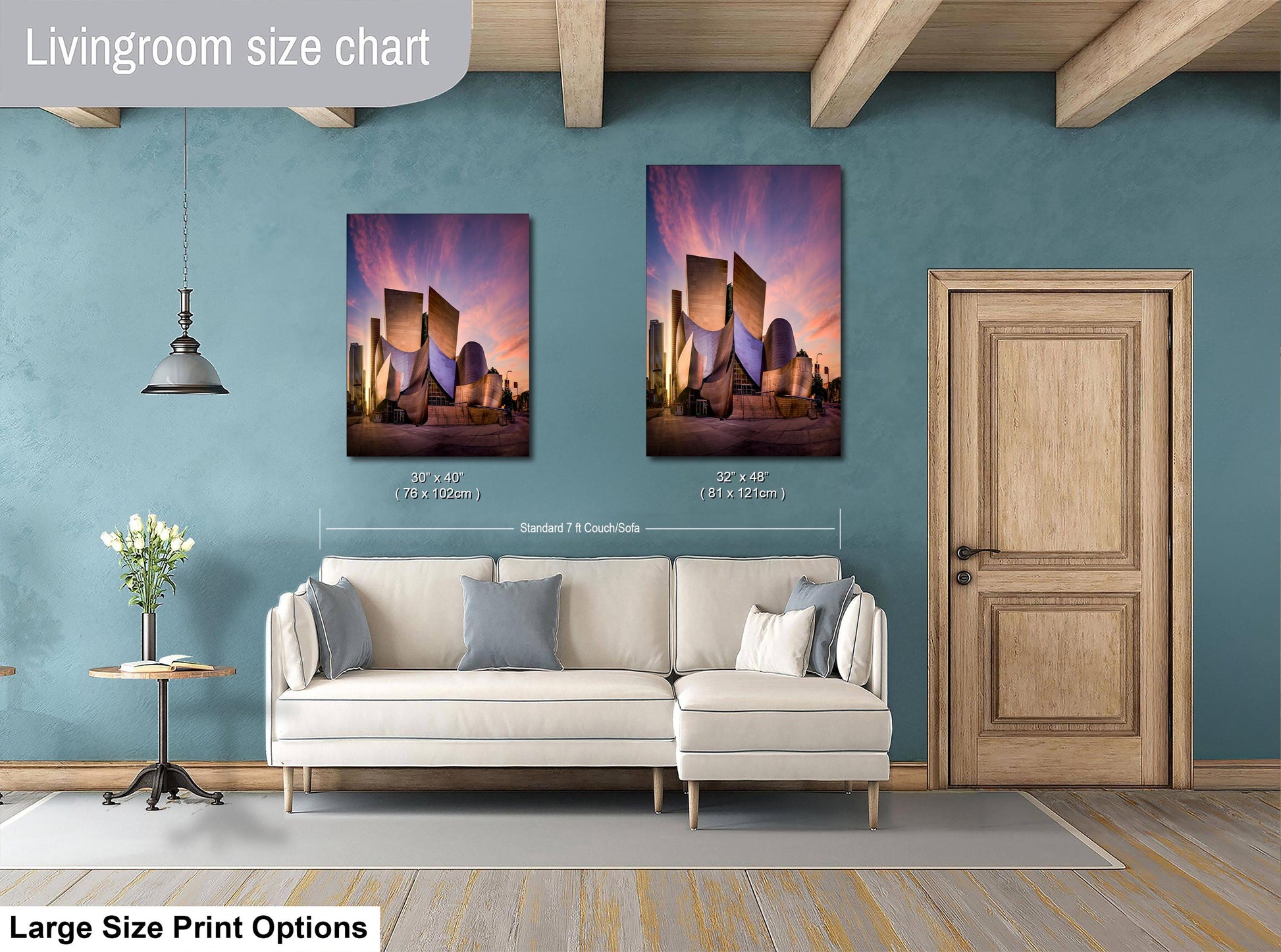 a living room with a white sofa, a wooden door, and two framed pictures of a city skyline hanging on the wall.