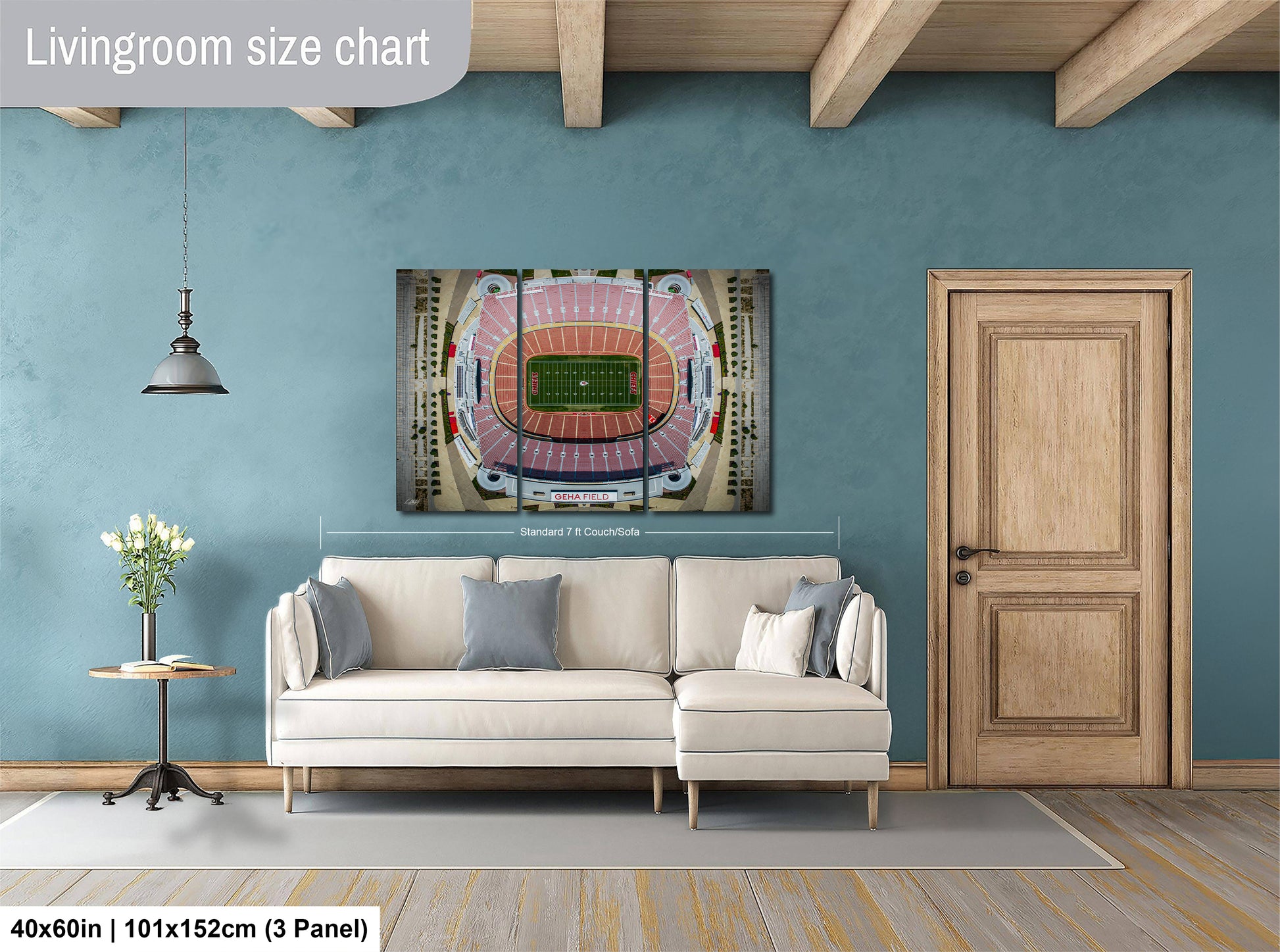 a living room with a large wall-mounted poster of a stadium, a white sofa, a wooden door, and a small table with a vase of flowers.