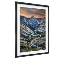 a breathtaking mountain landscape with a winding river flowing through the valley, surrounded by towering peaks under a vibrant, colorful sky.