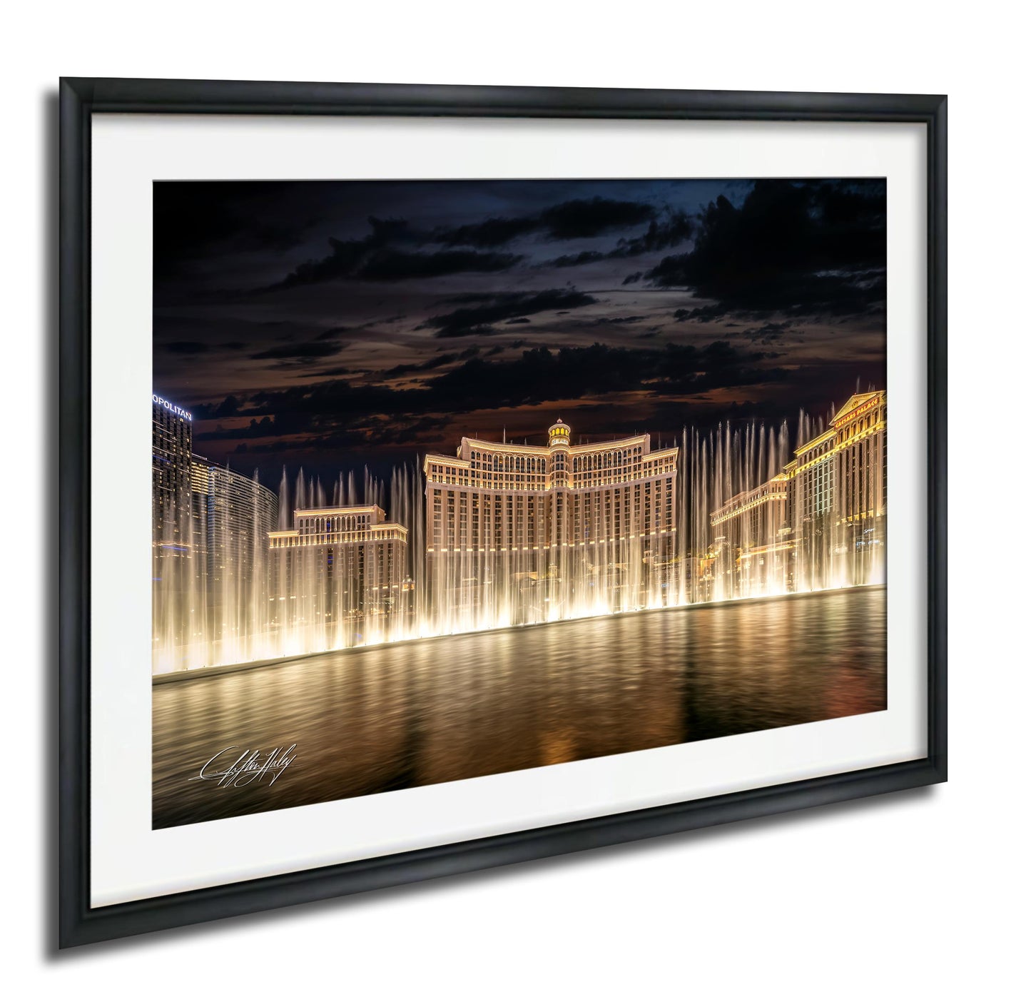 A framed photograph depicting the Bellagio Fountains in Las Vegas at night, with the fountains illuminated and creating a stunning reflection on the water surface.