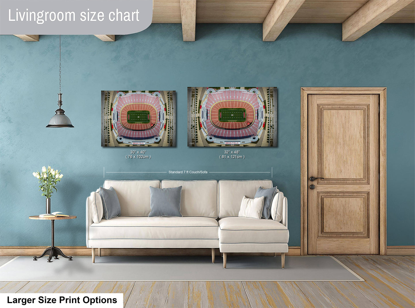 a living room with a white sofa, a wooden door, and two framed pictures of a stadium on the wall.