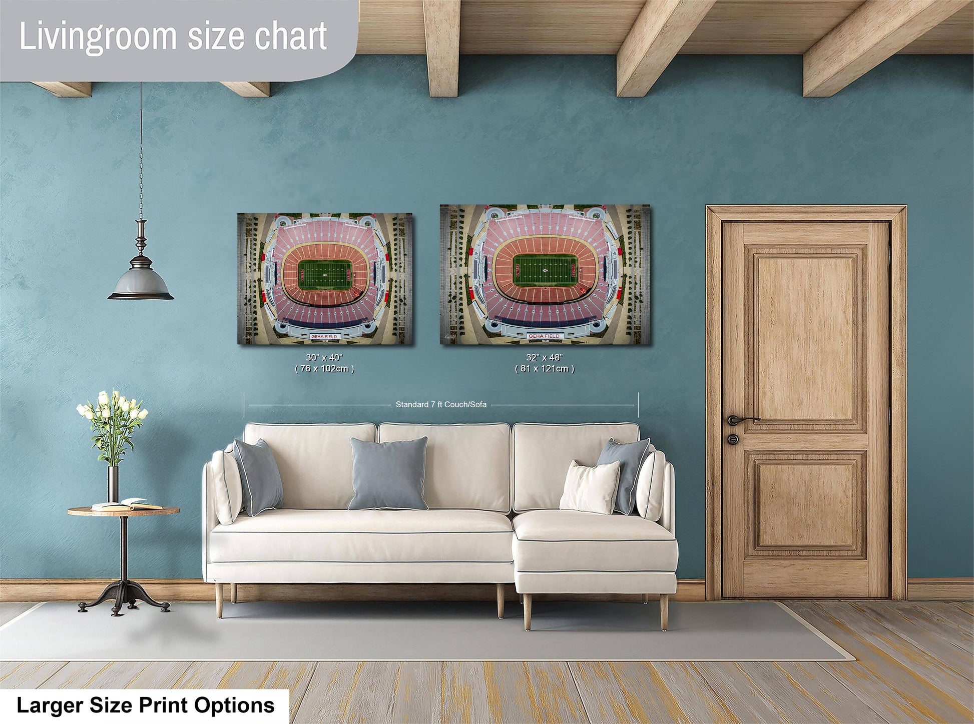 a living room with a white sofa, a wooden door, and two framed pictures of a stadium on the wall.
