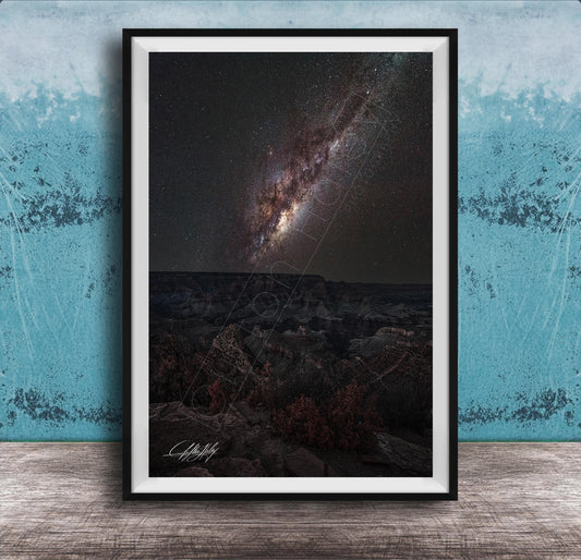 The image is a framed photograph of a night sky with a distant galaxy, set against a dark background.
