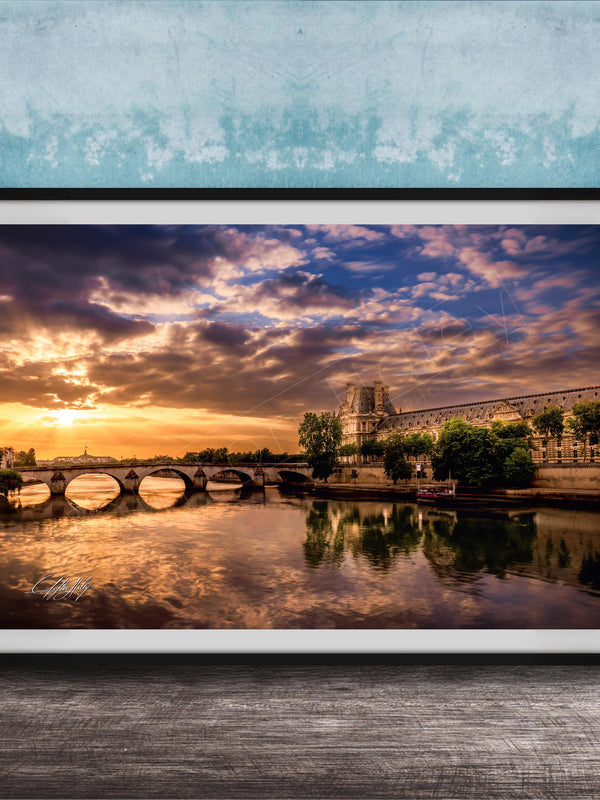 a picturesque scene of a river with a bridge, set against a stunning sunset sky with clouds.