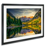 a serene mountain landscape with a lake reflecting the vibrant colors of the autumn foliage.