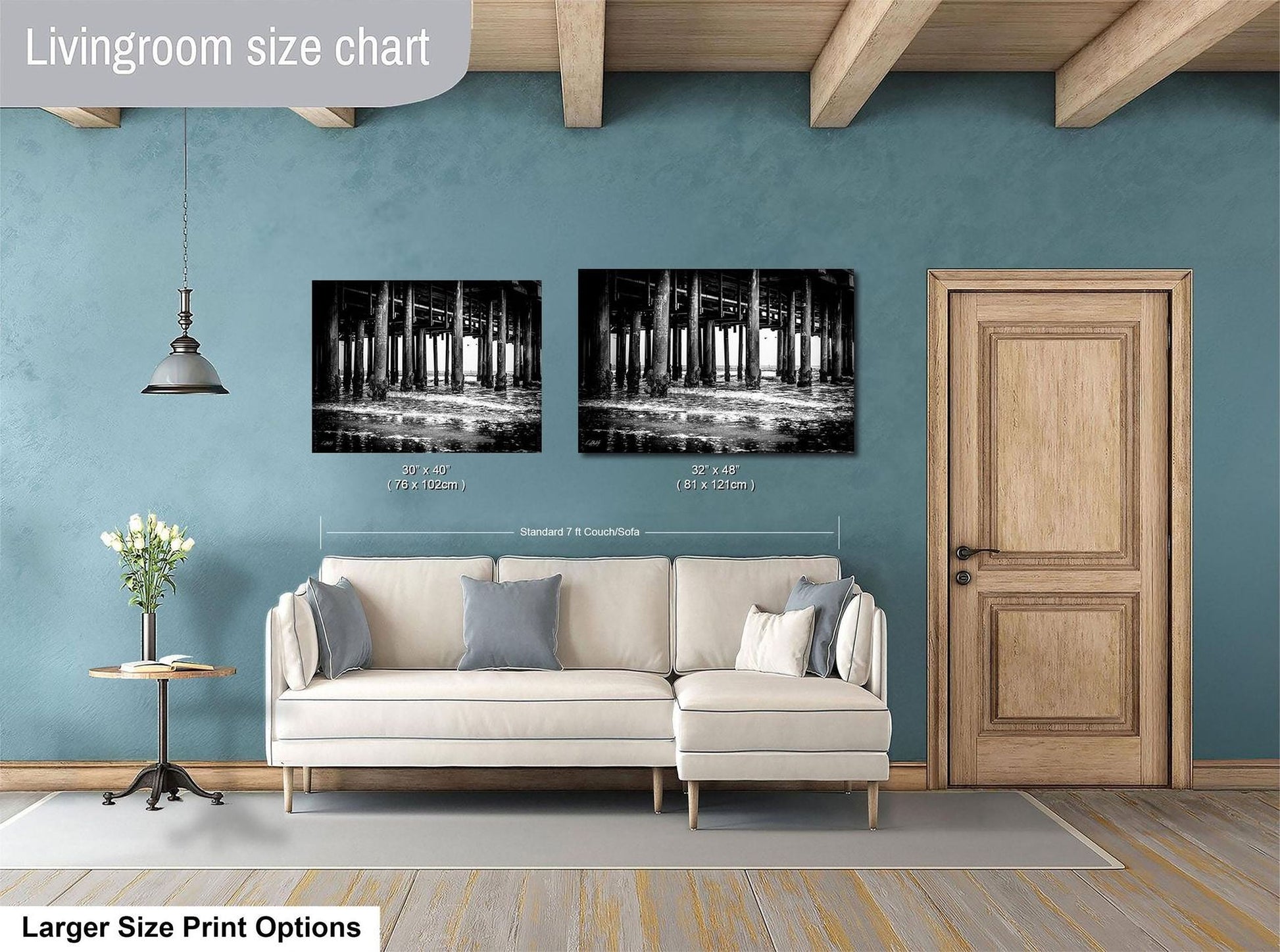 a living room with a white sofa, a wooden door, and two framed black and white photographs hanging on the wall.