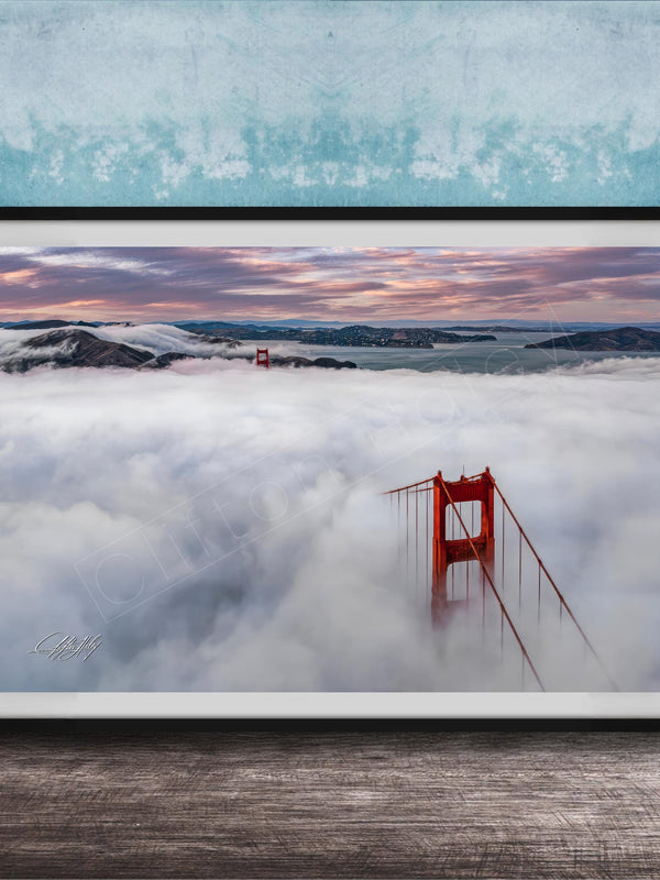 A framed photograph depicting the Golden Gate Bridge in foggy conditions, with the bridge's iconic red towers visible through the mist.