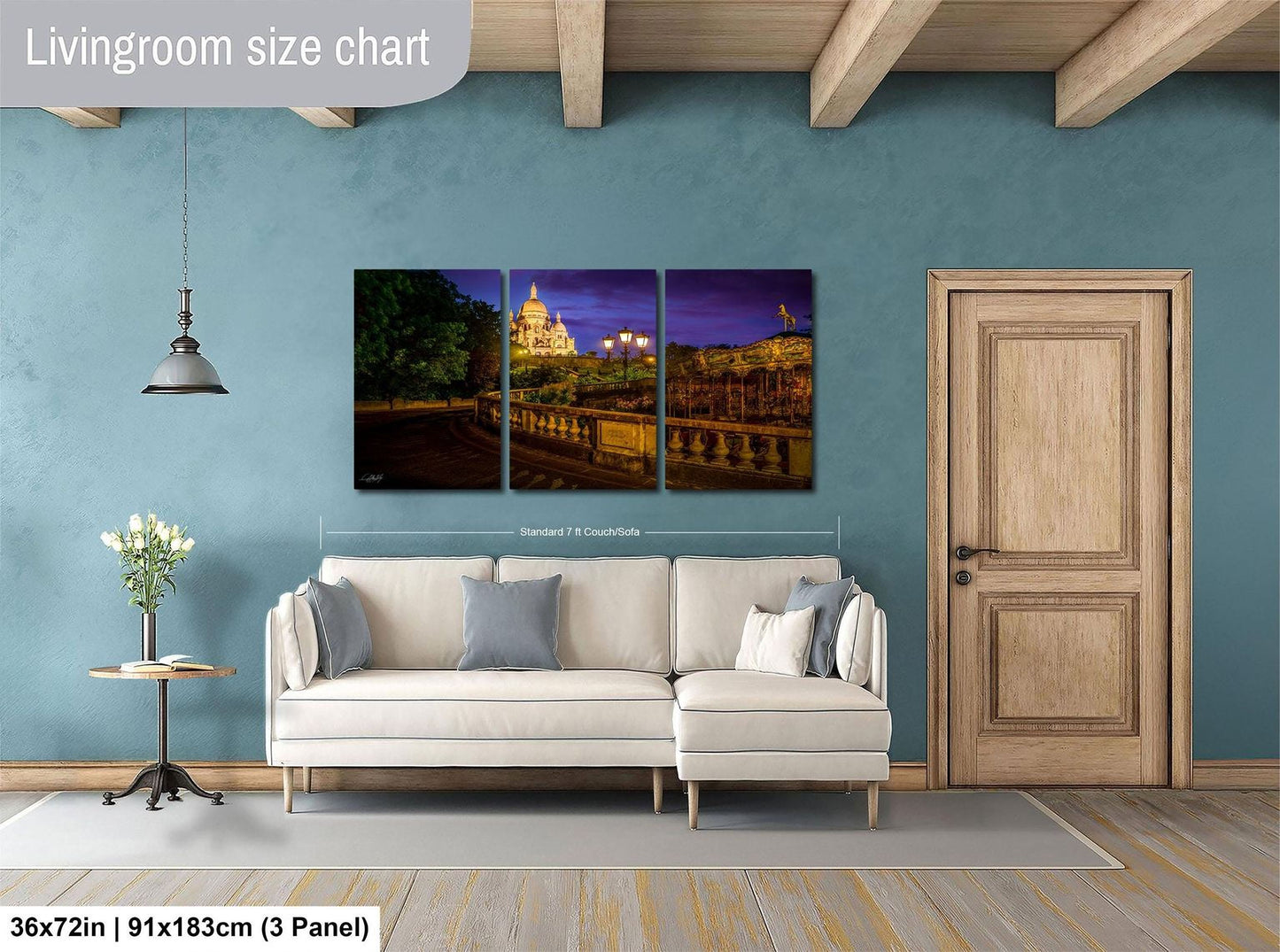 The image is a living room with a large white sofa, a wooden door, and a painting of a cityscape on the wall.