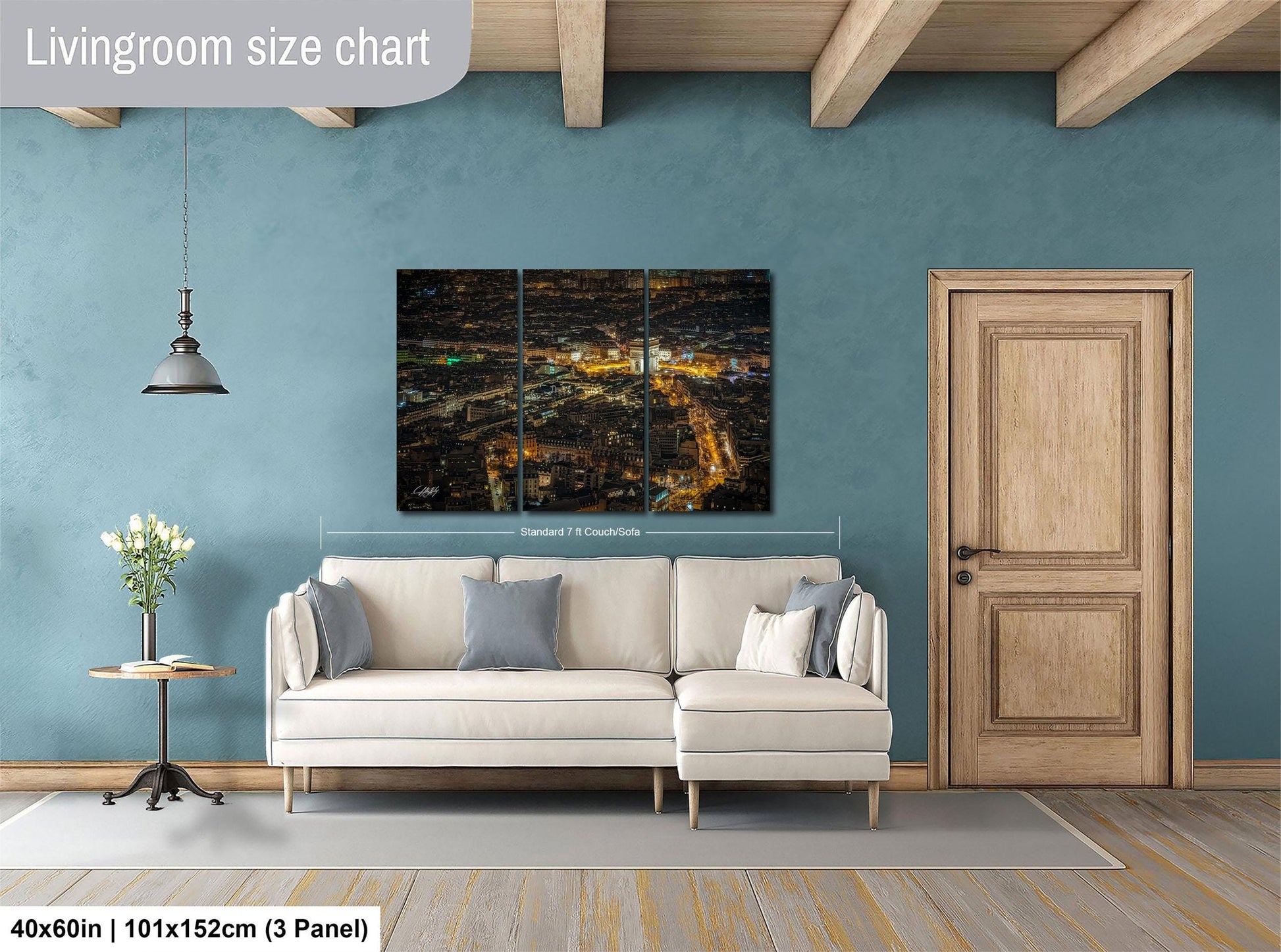 The image is a living room with a large, three-panel, high-resolution cityscape painting hanging on the wall. The painting depicts a nighttime city scene with illuminated buildings and streets. The room is furnished with a white sofa and a wooden door, and there is a potted plant and a vase on a side table. The living room size chart indicates that the space is approximately 40'x60', with a total height of 101'x152', and a width of 3' panel.