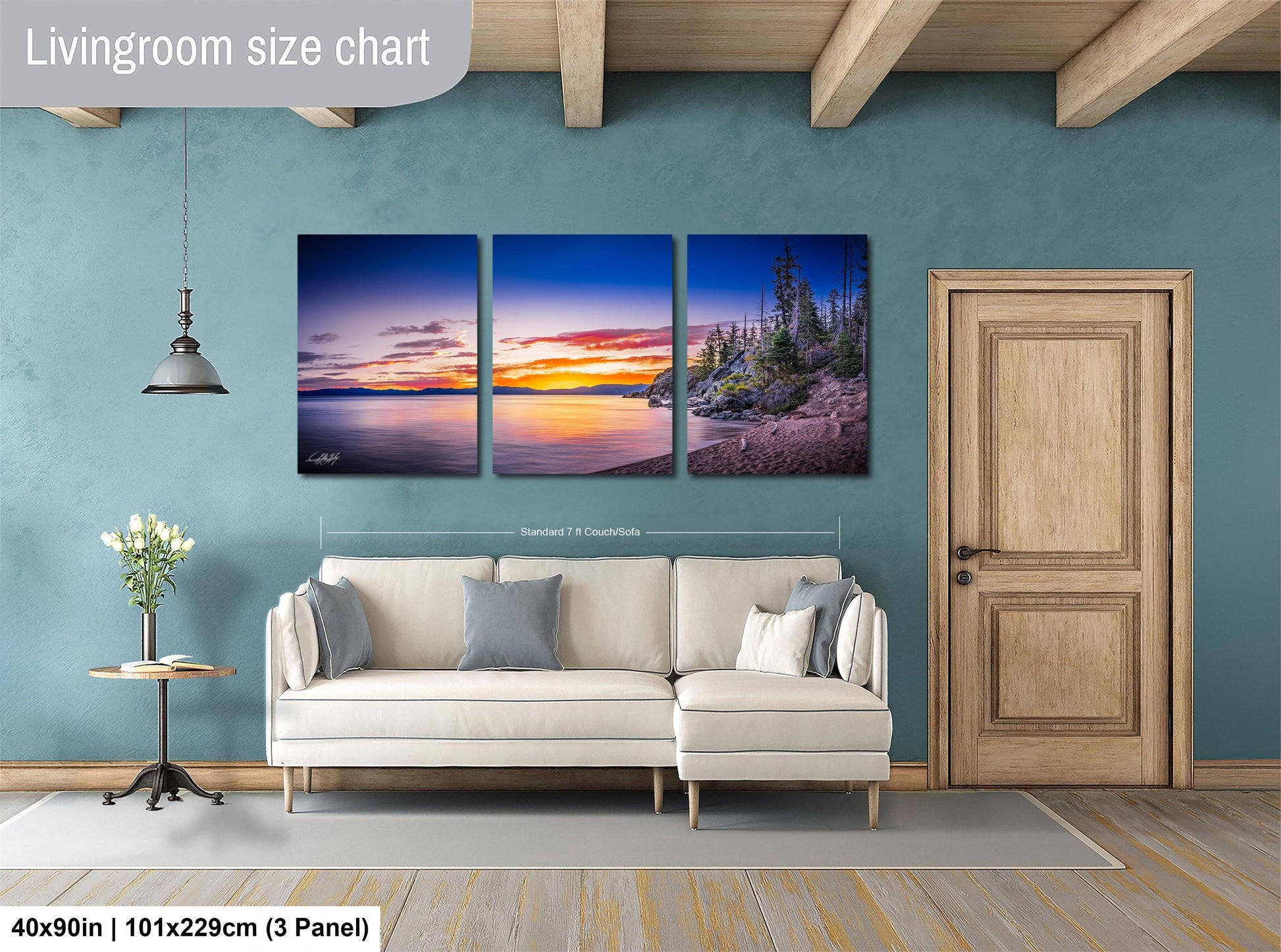 The image is a living room with a large wall art piece depicting a serene landscape with a sunset over a beach. The art piece is divided into three panels, each showcasing different aspects of the scene. The living room has a white sofa and a wooden door, creating a cozy and inviting atmosphere.