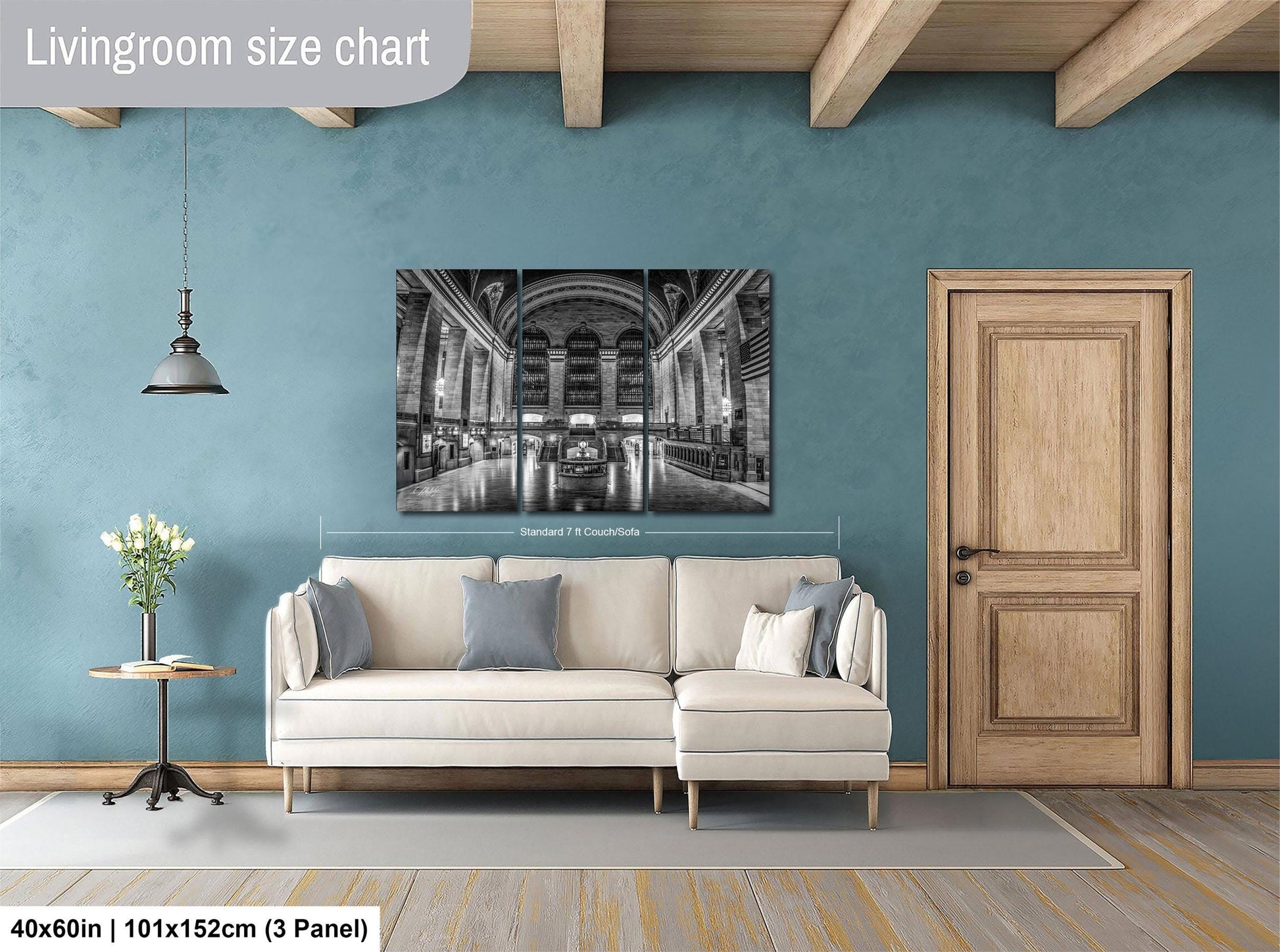 a living room with a large, black and white photograph of a grand, ornate building hanging on the wall. The room is furnished with a white sofa and a wooden door, and the floor is covered with a gray rug.