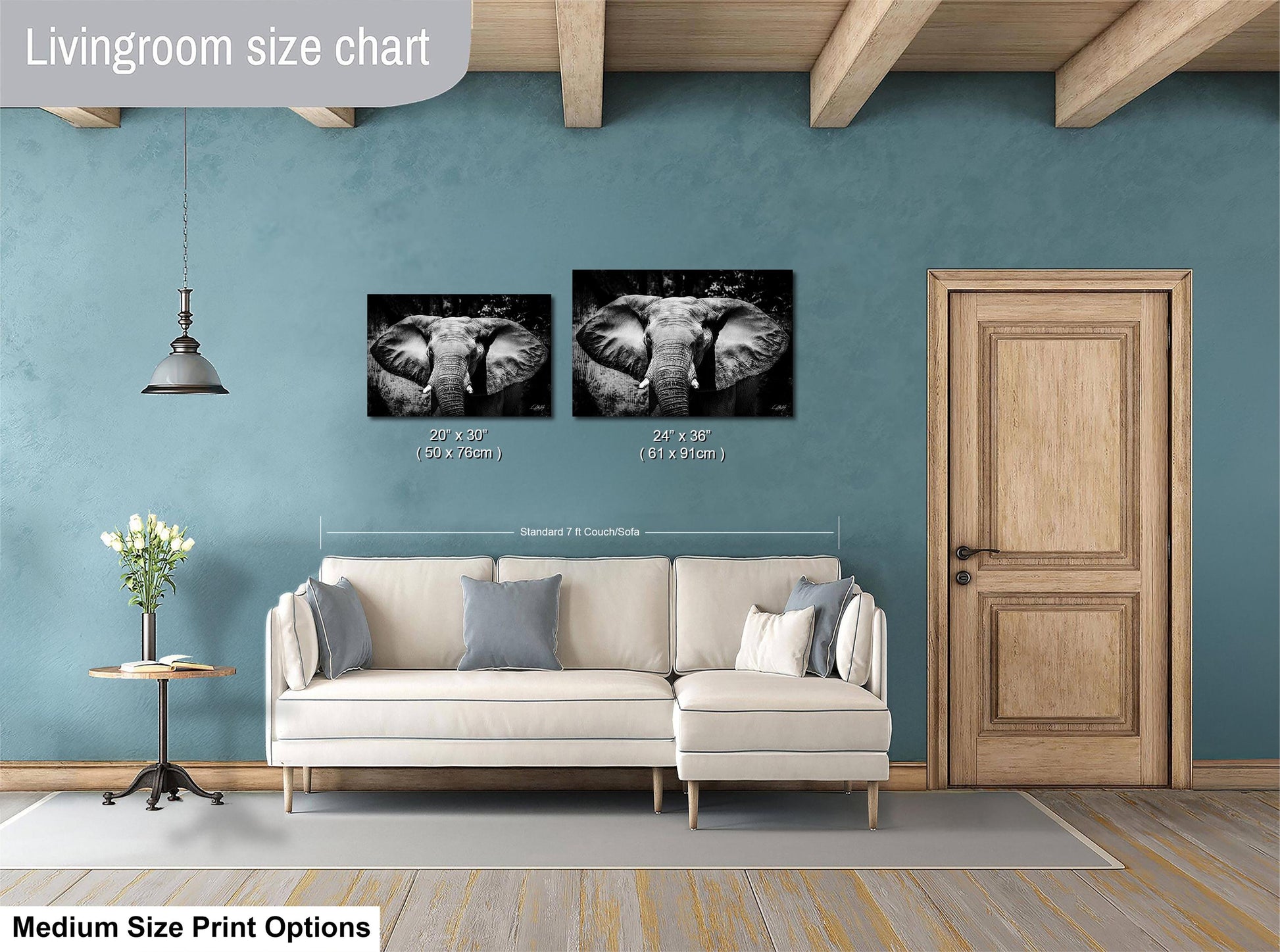 a living room with a white sofa, a wooden door, and a hanging light fixture. Above the sofa, there is a size chart for a medium-sized print, indicating the dimensions of the two black and white photographs of elephants.