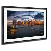 a city skyline at sunset, with the city's tall buildings illuminated against a darkening sky.