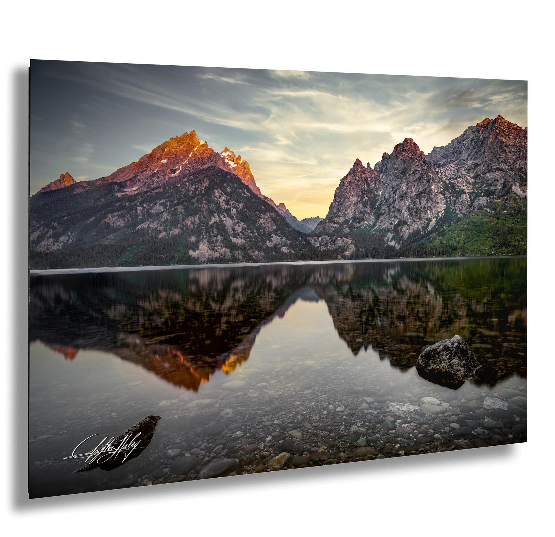 a serene mountain landscape with a calm lake reflecting the vibrant colors of the setting sun.