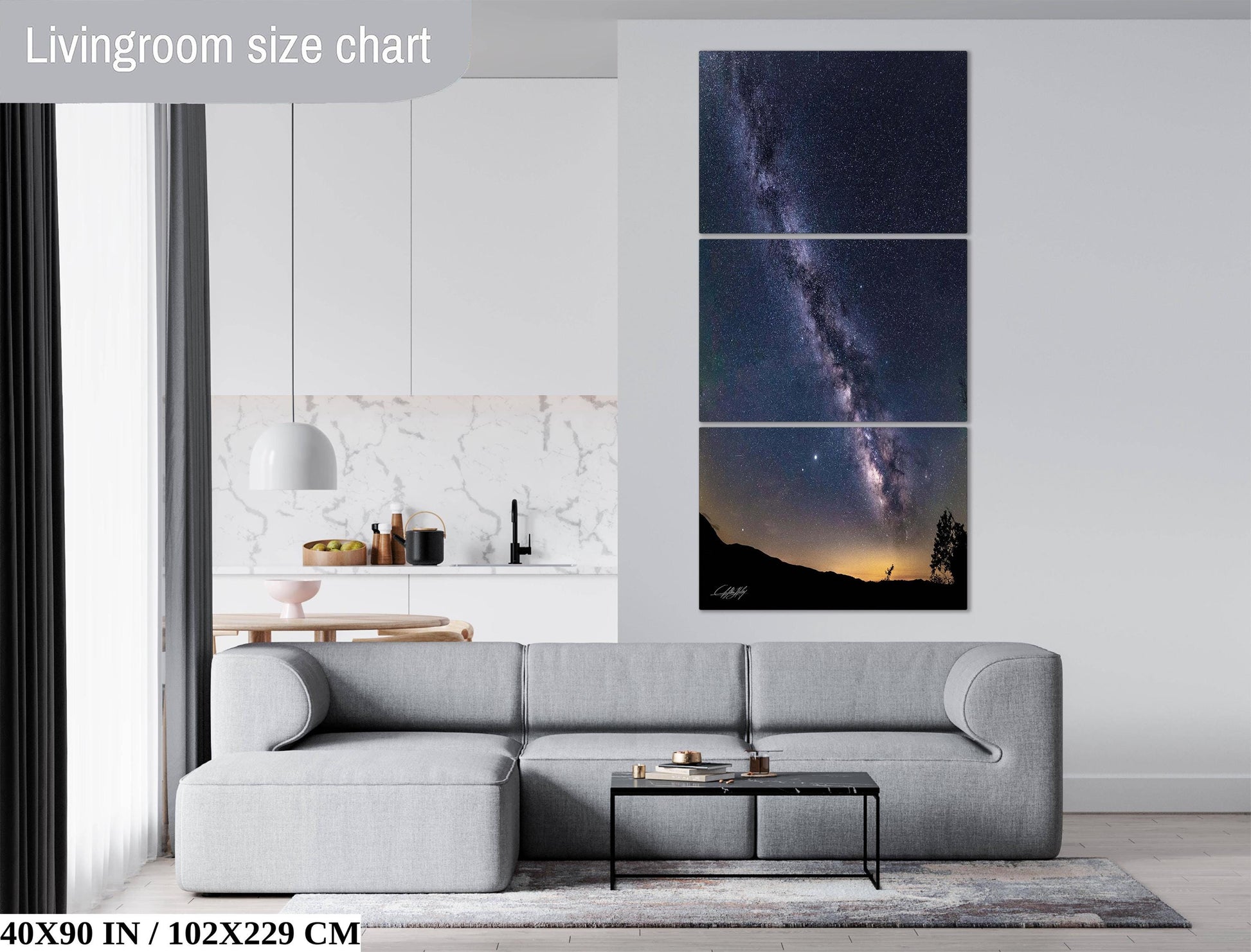 The image is a living room with a gray sofa, a coffee table, and a large wall art depicting a night sky with a galaxy.