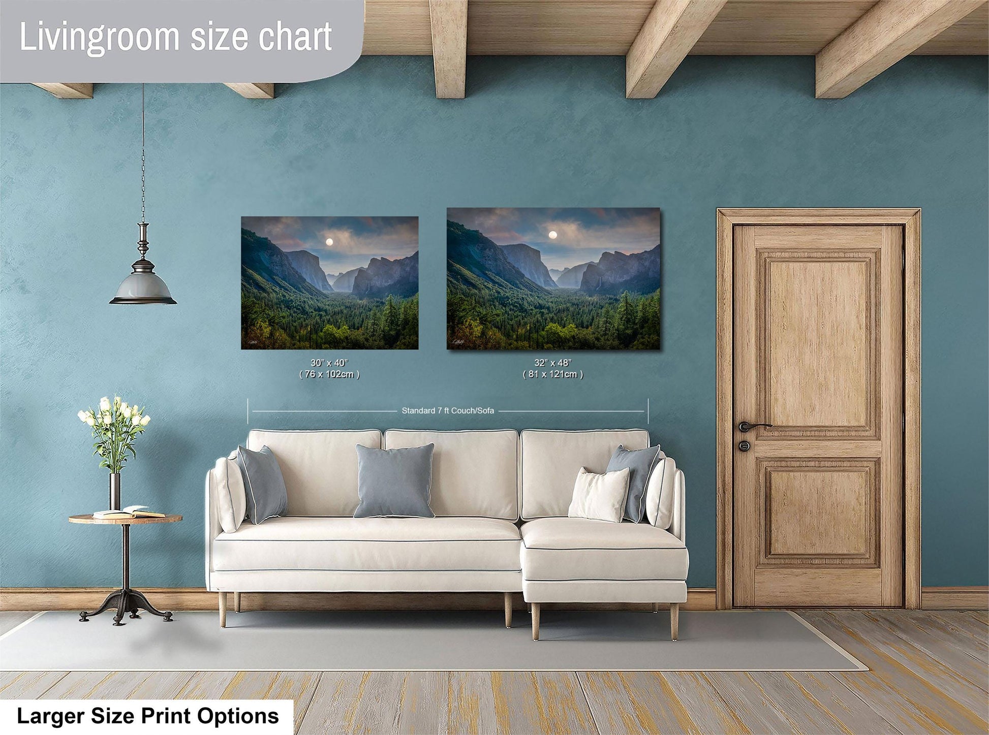 a living room with a white sofa, a wooden door, and two framed landscape paintings hanging on the wall.