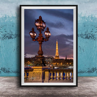 a cityscape with a lit-up lamppost and the Eiffel Tower in the background, set against a dark sky.