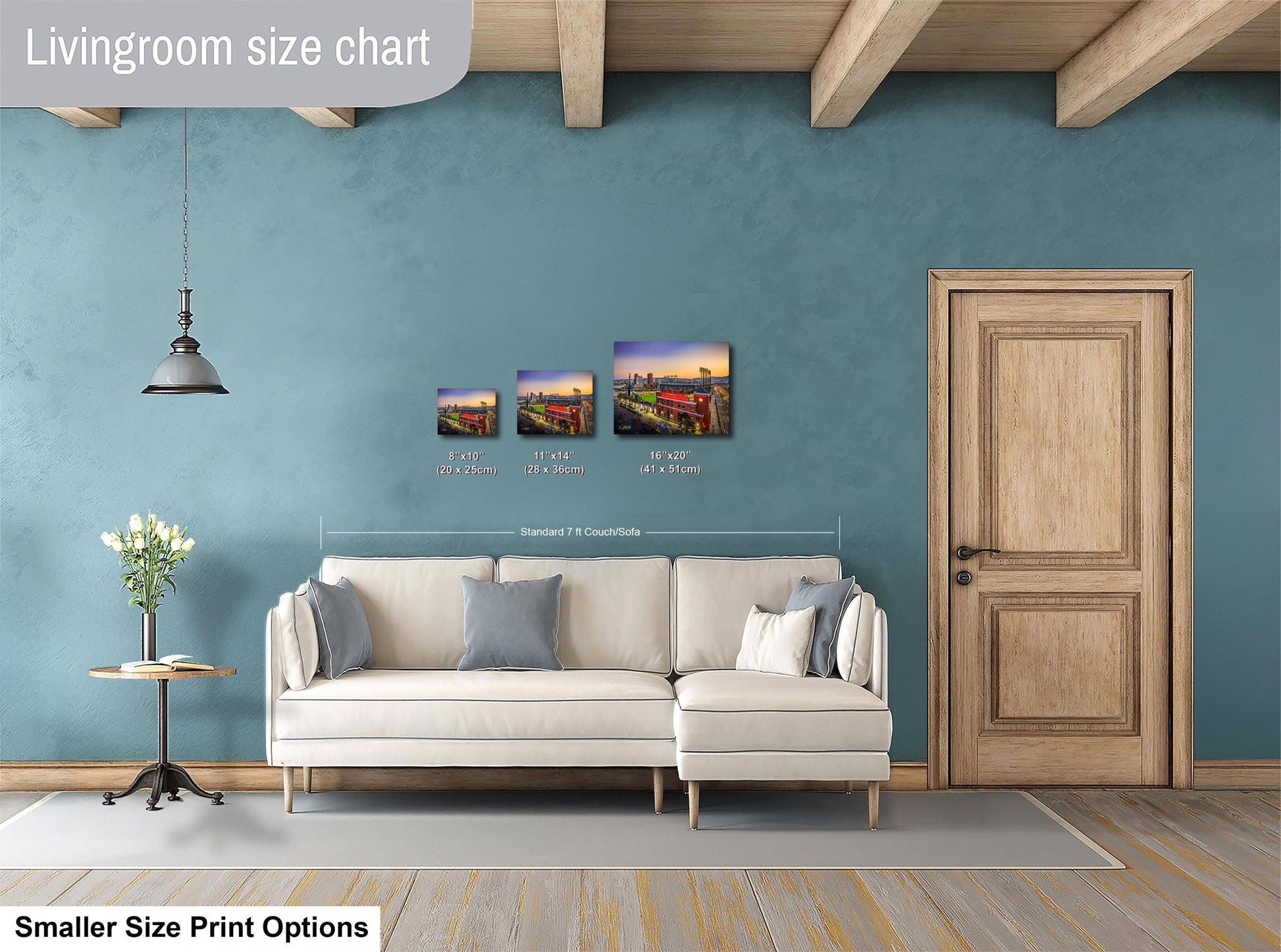 The image is a living room with a white sofa, a wooden door, and a hanging light fixture. There are three framed artworks displayed on the wall, each with different sizes and dimensions. The living room appears to be well-decorated and spacious.