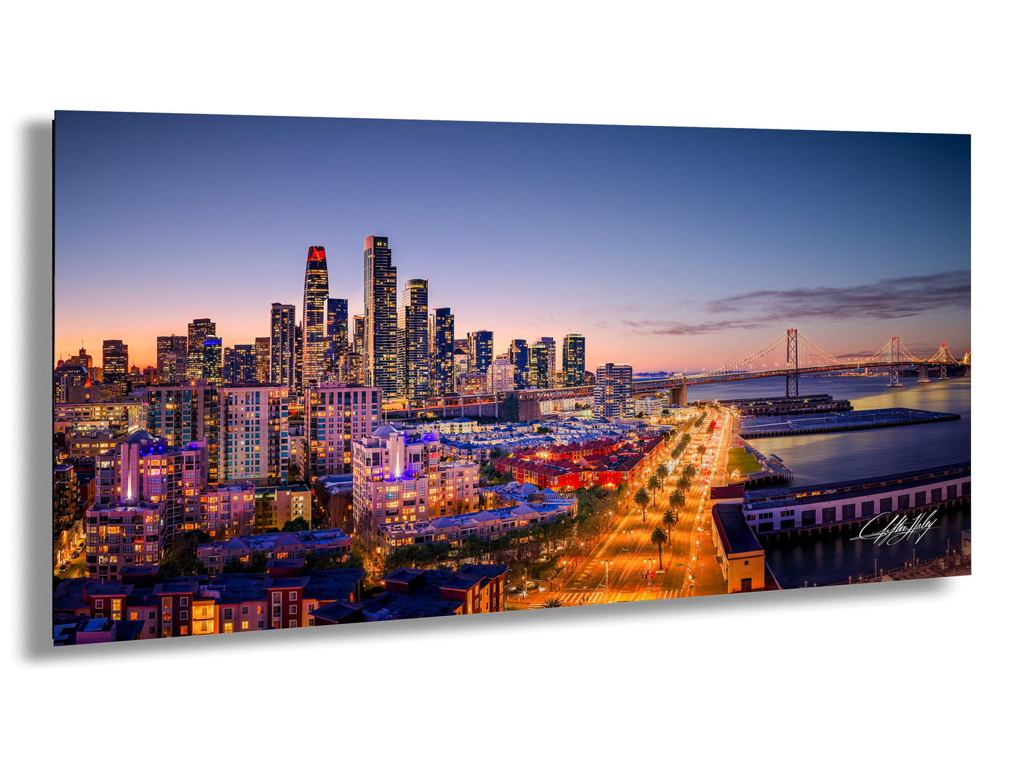 A stunning aerial view of a city skyline at dusk, with the buildings illuminated in vibrant colors against a deep blue sky.