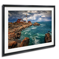 A framed photograph depicting a lighthouse on a rocky coastline, with the ocean and cloudy sky in the background.