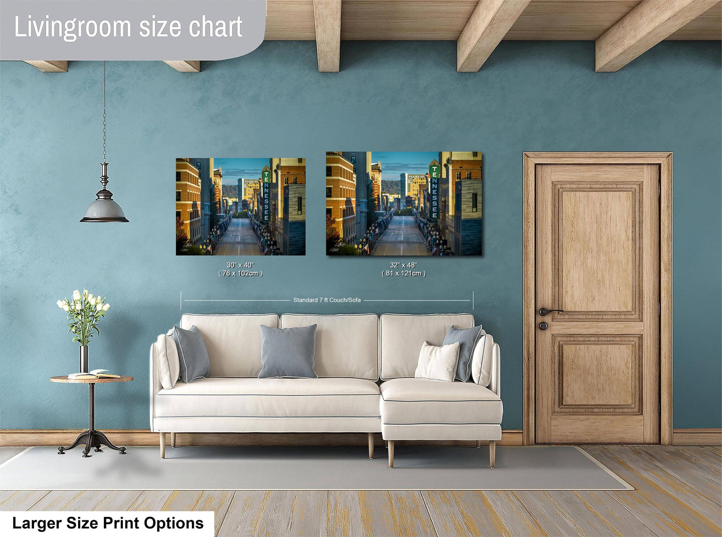 a living room with a white sofa, a wooden door, and a painting of a city street on the wall.