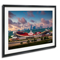 A framed photograph of the Kansas City Chiefs football stadium, with the city skyline in the background.