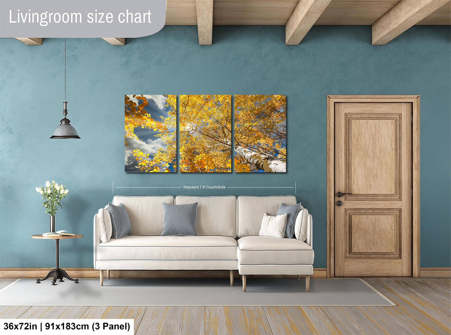 The image is a living room with a white sofa, a wooden door, and a large wall art depicting a tree with yellow leaves. The wall art is a collage of three panels, and the living room is described as having a blue wall and a wooden floor.