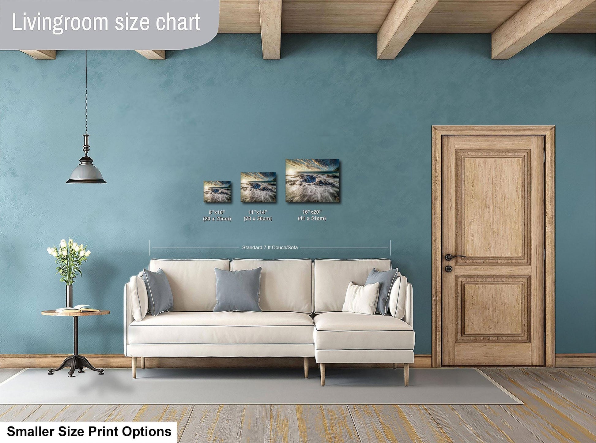 a living room with a white sofa, a wooden door, and a hanging light fixture. There are three framed artworks displayed on the wall above the sofa, each with different sizes and dimensions. The living room appears to be designed for a smaller space, as indicated by the "Smaller Size Print Options" text at the bottom of the image.