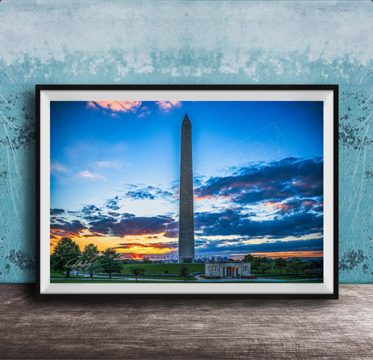 a photograph of the Washington Monument at sunset, with the sky filled with vibrant colors and clouds.