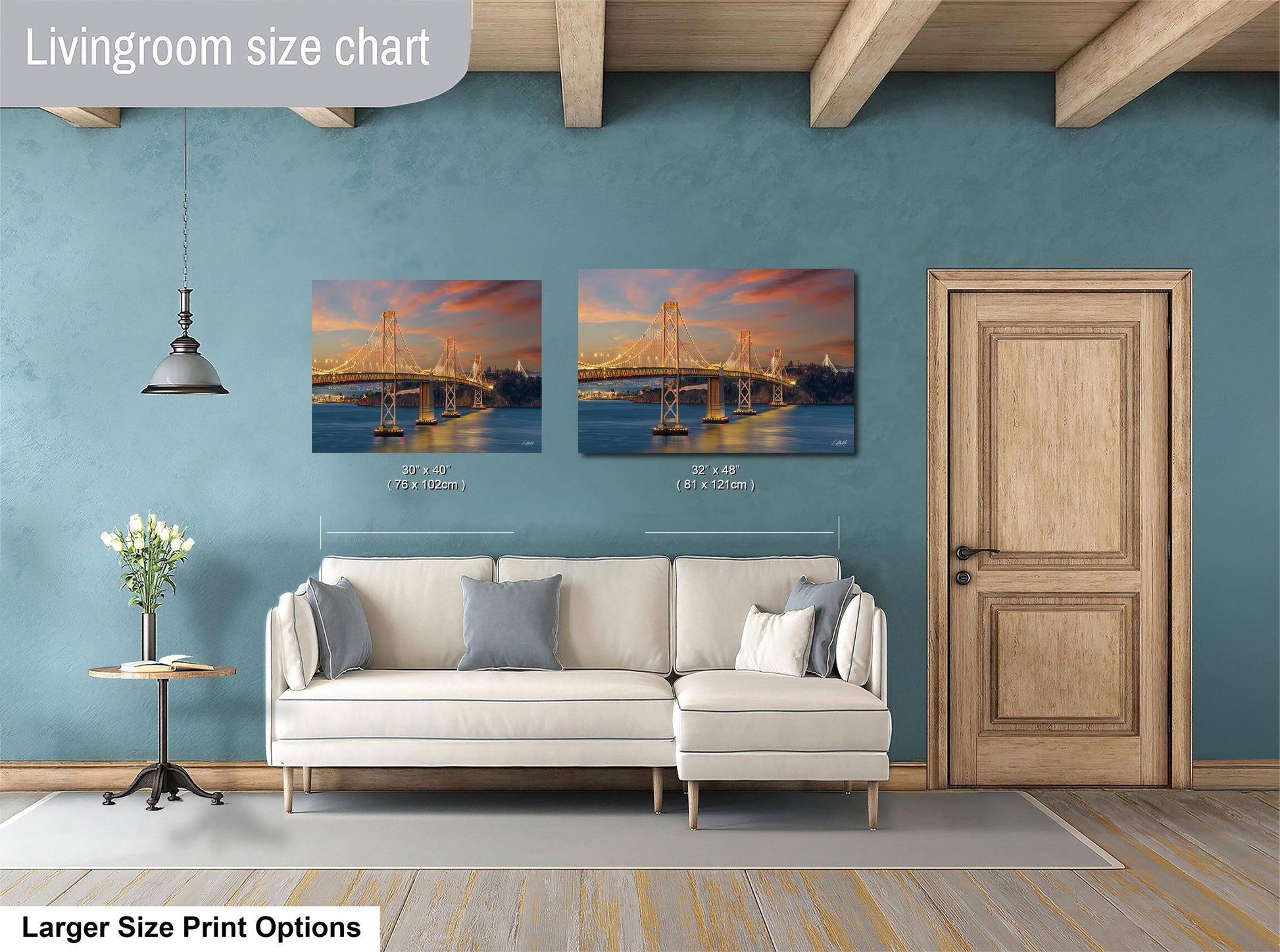 a living room with a white sofa and a wooden door. Above the sofa, there are two framed pictures of a bridge at sunset, with the size of the pictures being 30x60 inches and 31x42 inches.