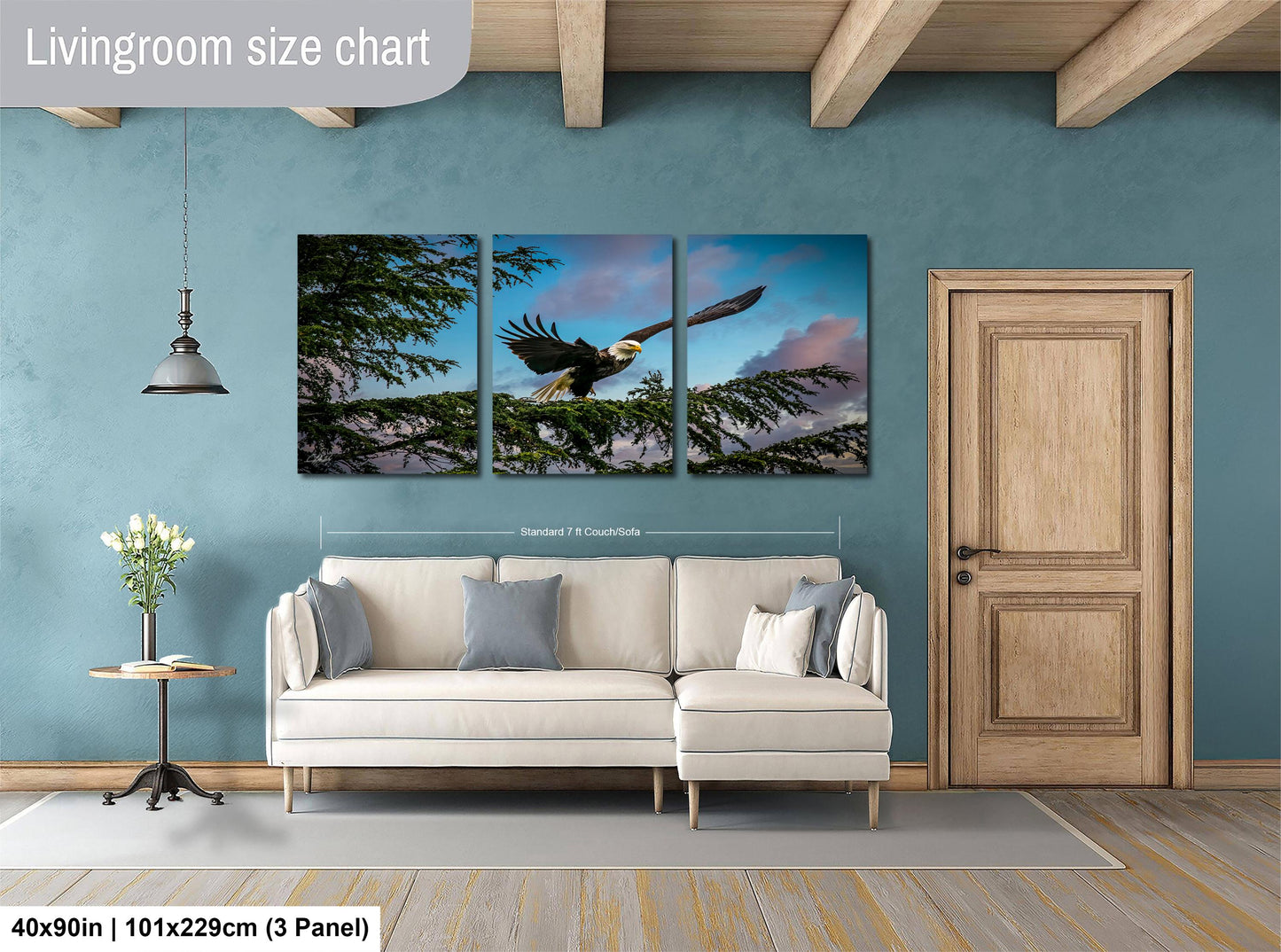 The image is a living room with a large white sofa, a wooden door, and a painting of a bird in flight on the wall.