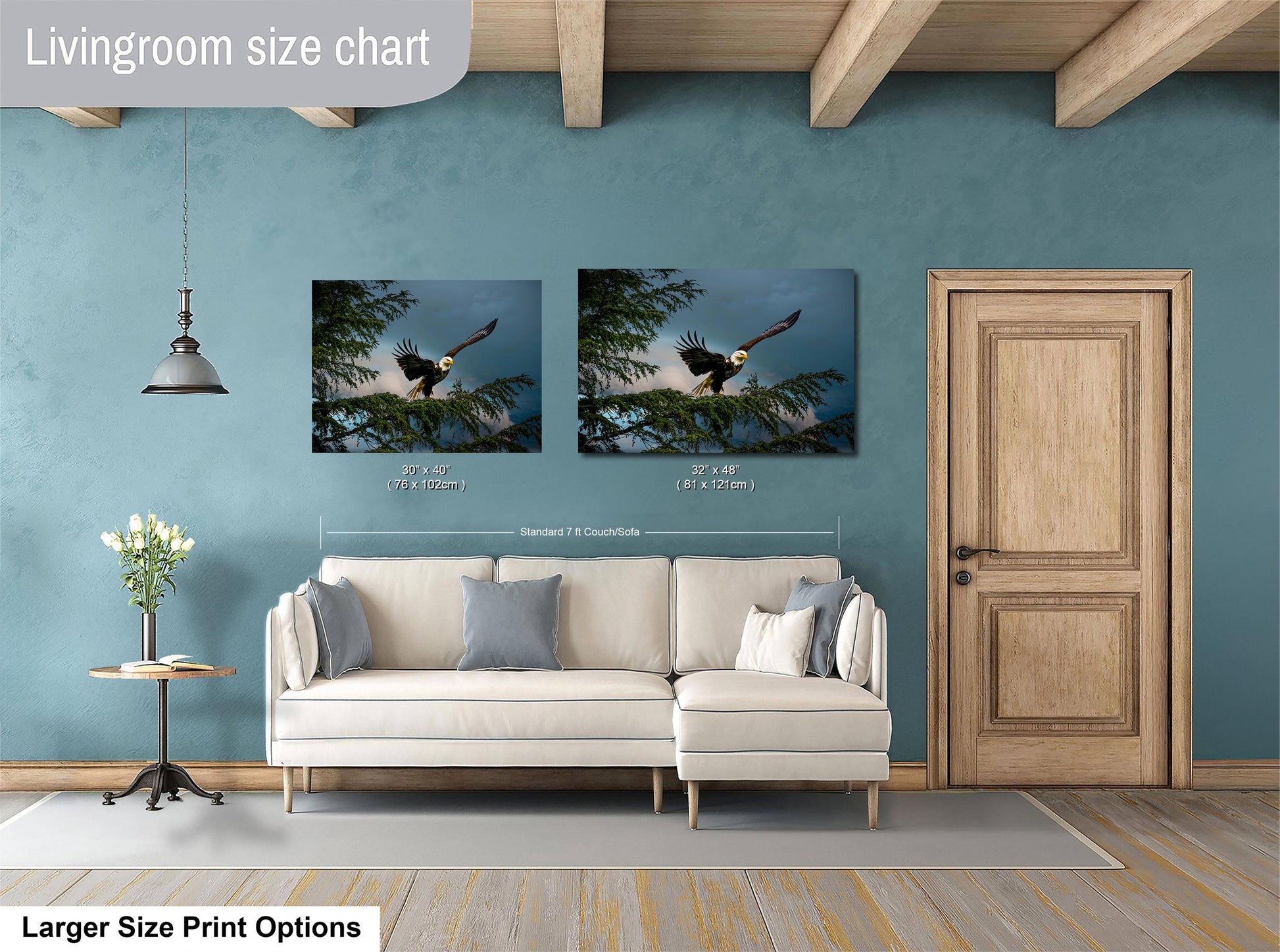 a living room with a white sofa, a wooden door, and two framed pictures of a bald eagle perched on a tree branch. The living room appears to be well-lit and decorated with a vase of flowers on a side table.