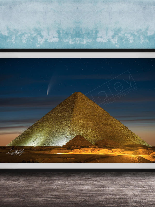 A framed photograph of the Great Pyramid of Giza at night, with a bright star visible in the sky above the pyramid.
