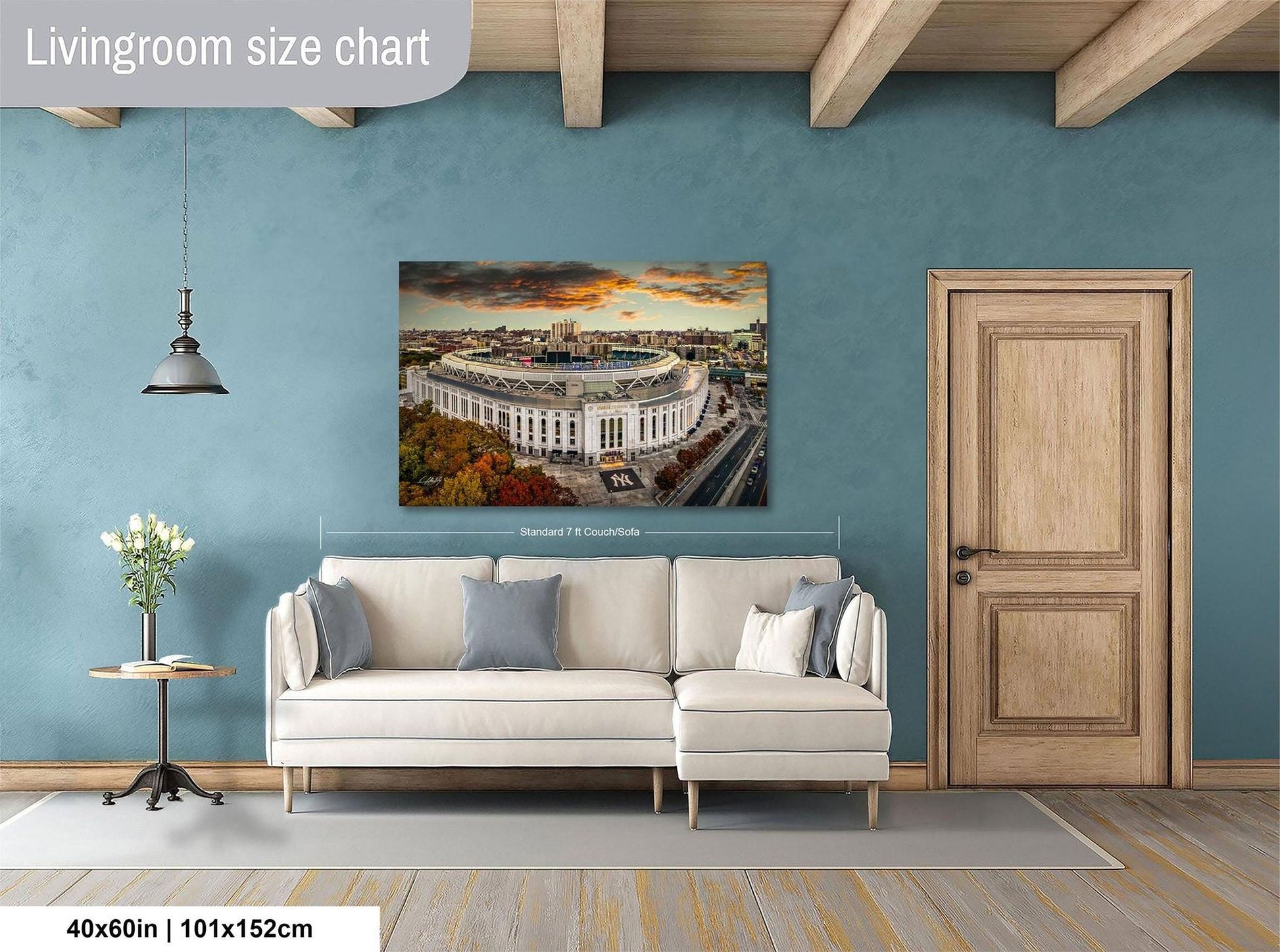 a living room with a large white sofa, a wooden door, and a painting of a stadium on the wall.