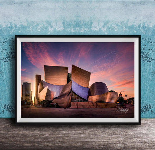 A framed photograph of the Guggenheim Museum in Bilbao, Spain, at sunset, with the distinctive curved architecture of the building illuminated against a colorful sky.