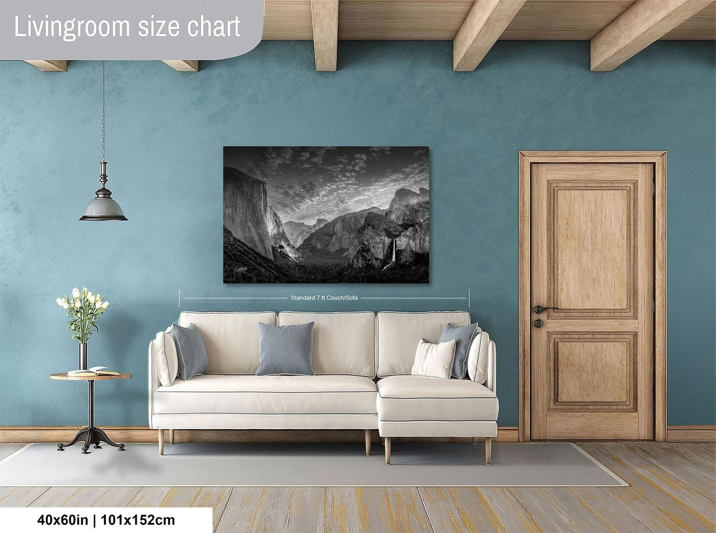 a living room with a large black and white landscape painting hanging on the wall above a white sofa.