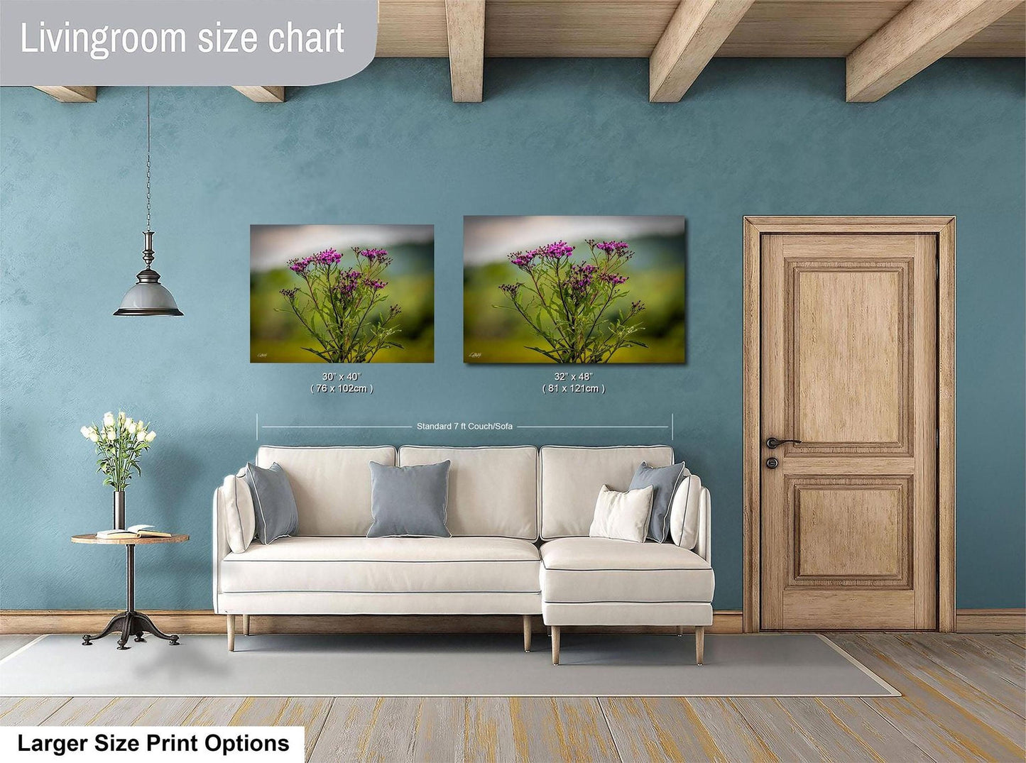 a living room with a white sofa, a wooden door, and two framed pictures of flowers hanging on the wall.