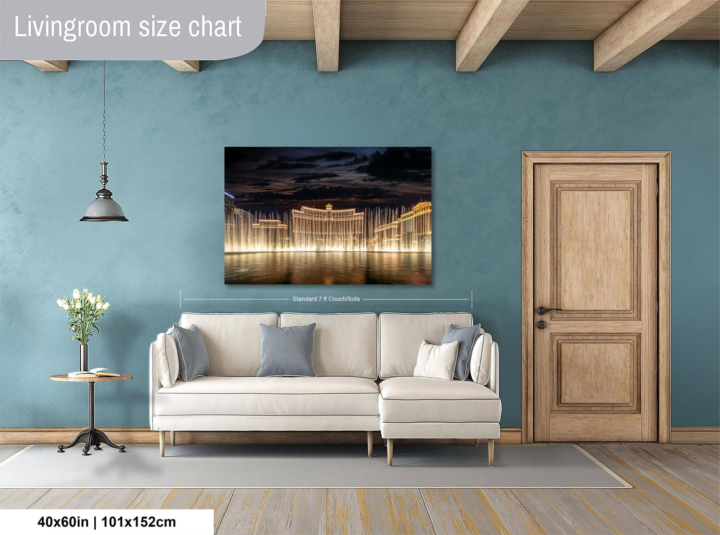 a living room with a large white sofa, a wooden door, and a painting of a city skyline at night.