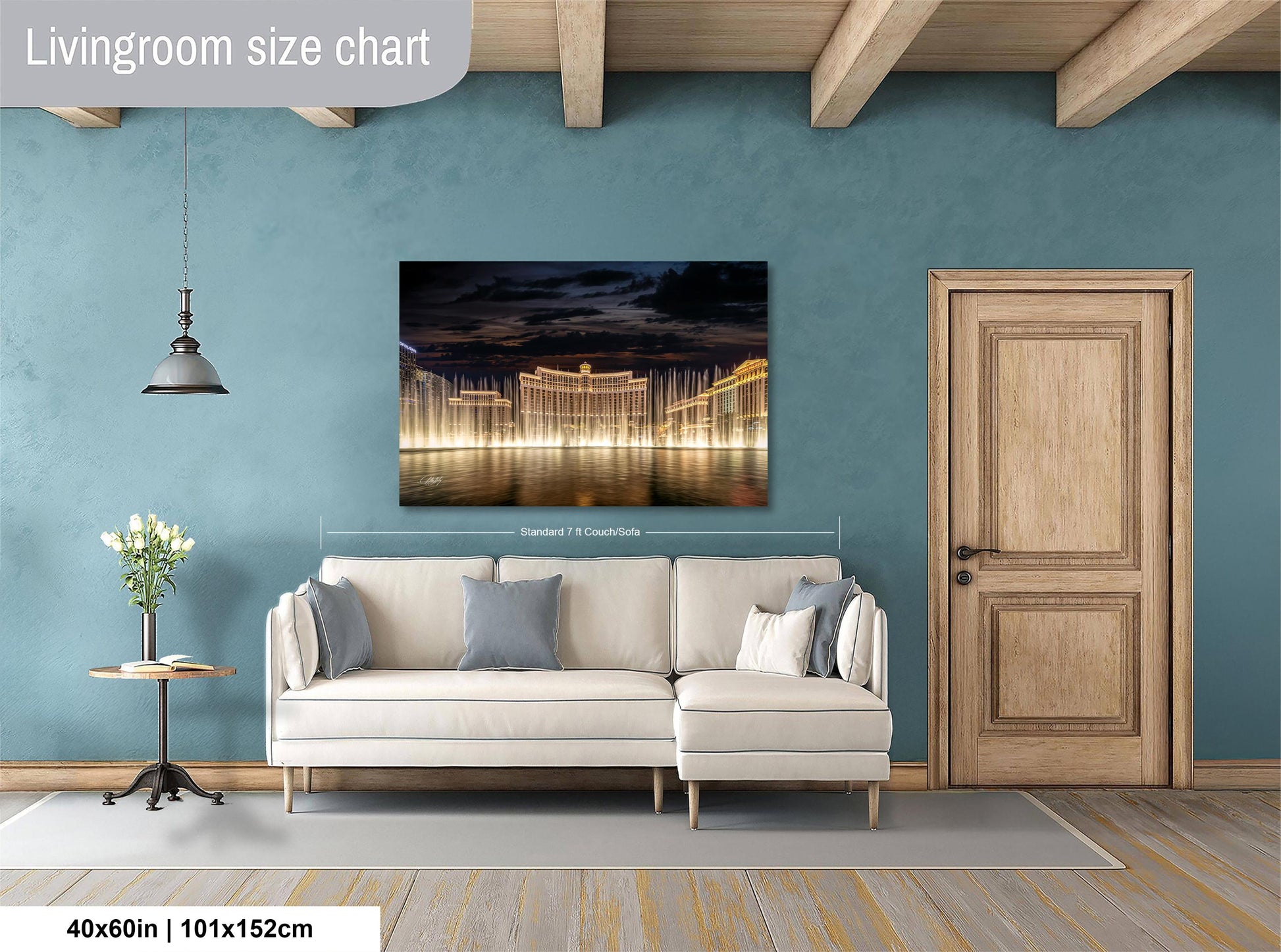 a living room with a large white sofa, a wooden door, and a painting of a city skyline at night.