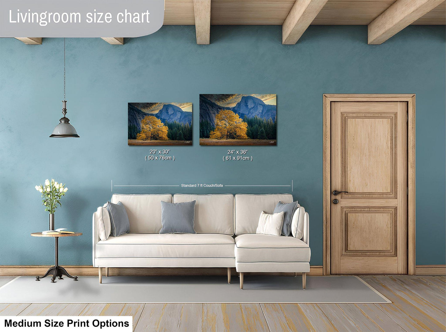 a living room with a white sofa, a wooden door, and a painting of a mountain landscape on the wall. The painting is of a size chart, indicating the dimensions of the artwork in relation to the sofa.