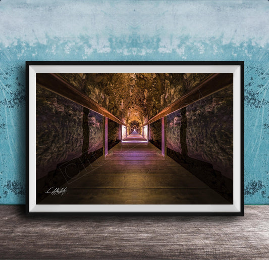 a long, dimly lit tunnel with a wooden floor and walls, creating a sense of depth and mystery.