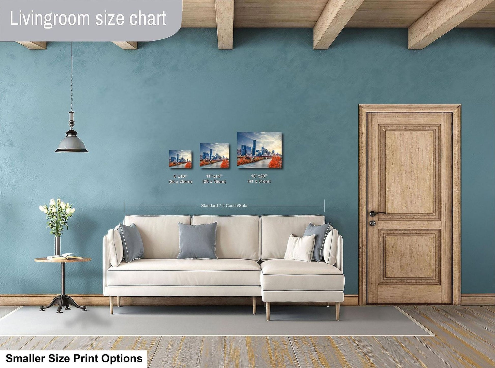 a living room with a white sofa, a wooden door, and a hanging light fixture. There are three framed artworks displayed on the wall, each with a different size and resolution. The living room appears to be designed for a smaller space, as indicated by the "Smaller Size Print Options" text at the bottom of the image.