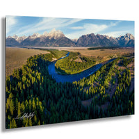 a serene landscape with a winding river surrounded by lush green forests and majestic snow-capped mountains in the background.