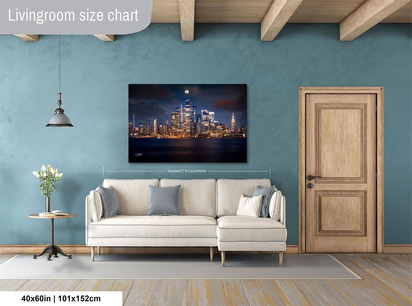 a living room with a large city skyline painting hanging on the wall. The painting is framed and measures 40 inches by 101.5 centimeters. The room has a white sofa, a wooden door, and a small table with a vase of flowers.