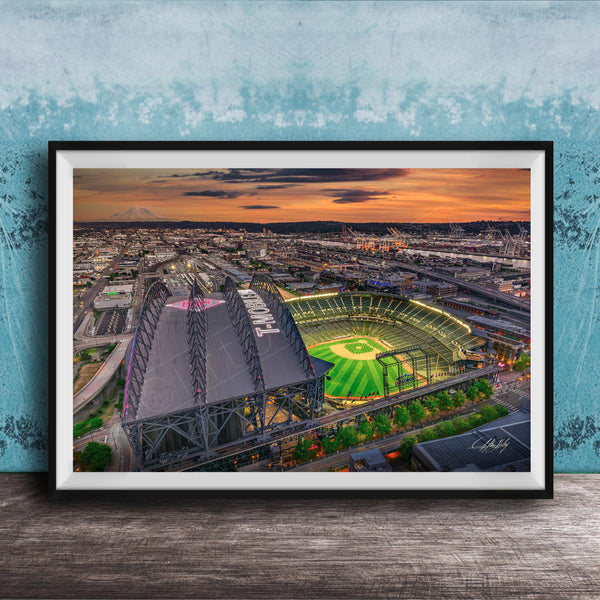 The image is a framed aerial view of a baseball stadium at night, with the stadium lights illuminating the field and surrounding area.