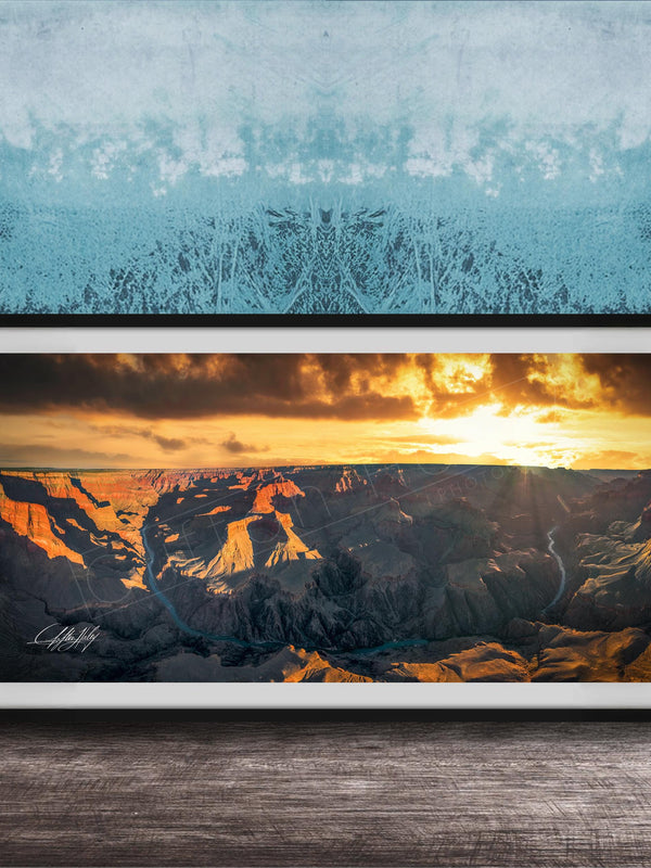 A framed photograph of a breathtaking landscape, depicting a dramatic sunset over a rugged mountain range.